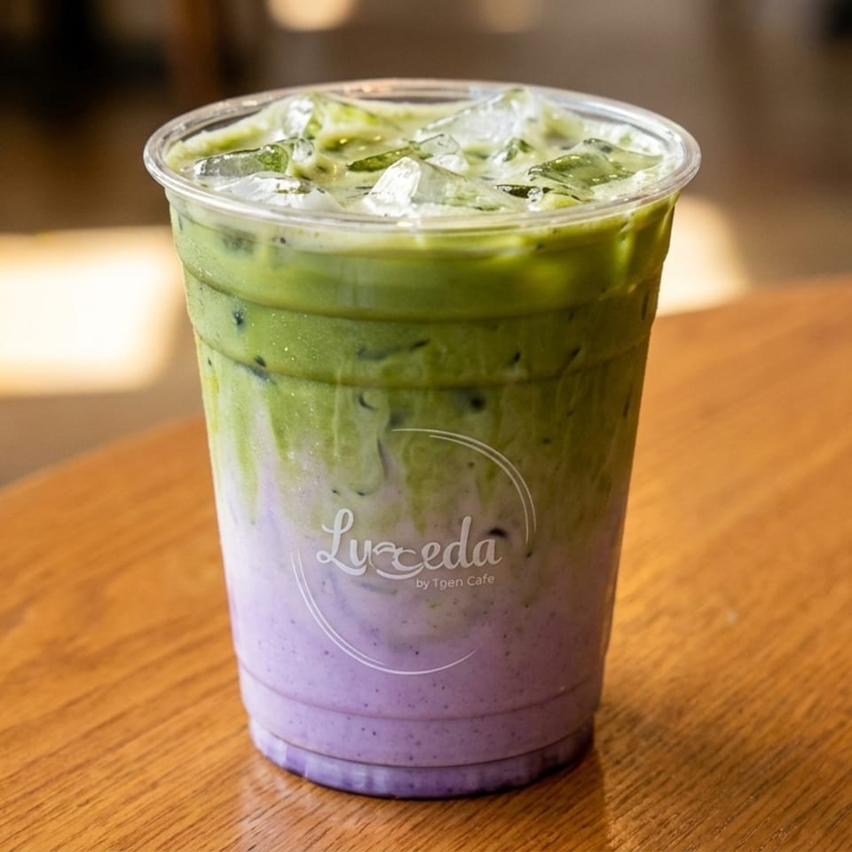 Iced matcha latte with purple taro swirl, topped with ice, on a wooden table.